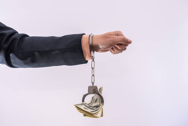 Bribe or corruption concept male hands hold dollar bills in handcuff. criminal - Zdjęcie, obraz