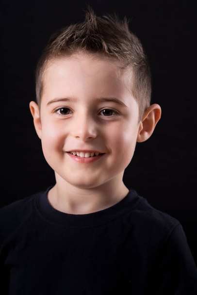 Portrait of happy joyful beautiful little boy, studio shot on black background - Photo, Image