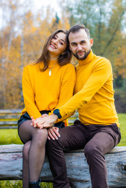 Couple of lovers dressed in yellow turtlenecks in the park hugging - Photo, Image