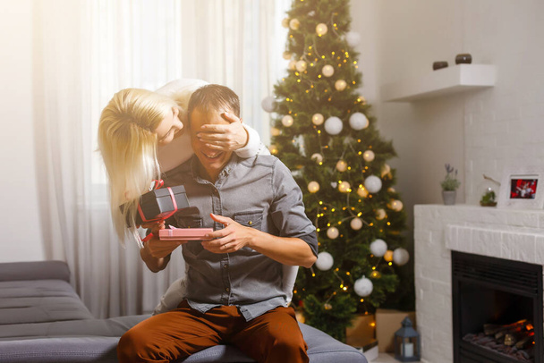 Pareja intercambiando regalos de Navidad cerca del árbol de Navidad. - Foto, Imagen