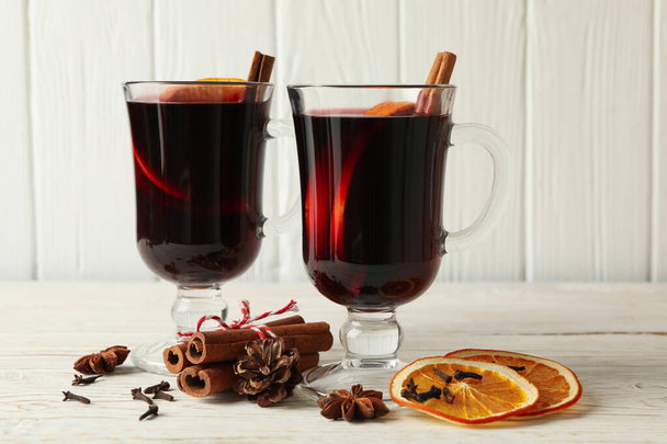 Cups of mulled wine and ingredients on wooden background - Valokuva, kuva
