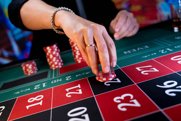 Woman playing at the roulette table at the casino - Foto, Imagen