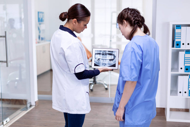 Zahnarzt und Krankenschwester betrachten digitales Teeh-Röntgen - Foto, Bild