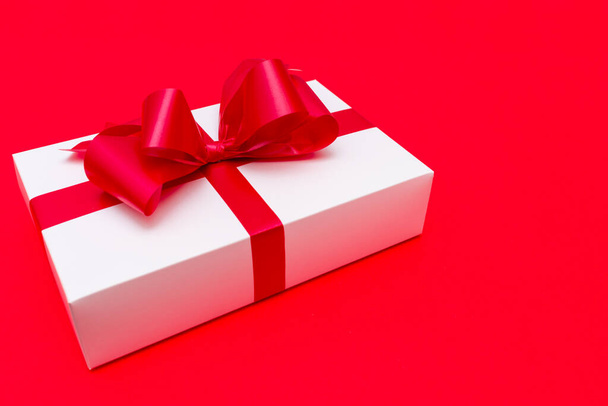 Top view White gift box red ribbon flat lay red background.Christmas concept. - Fotoğraf, Görsel
