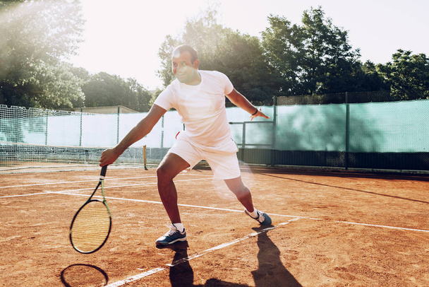 Fit man plays tennis on tennis field - Φωτογραφία, εικόνα