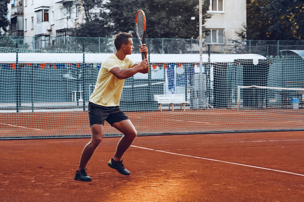 Young handsome man playing tennis on the tennis court - Fotoğraf, Görsel