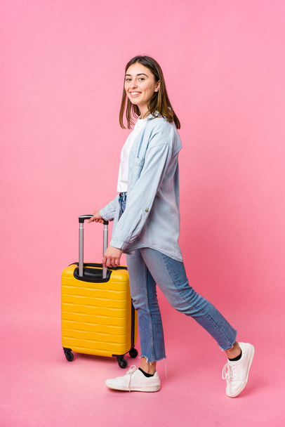 Young caucasian woman going to traveler isolated on pink background - Фото, зображення