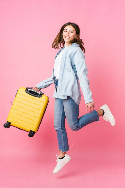 Young caucasian woman going to traveler isolated on pink background - Foto, Imagem