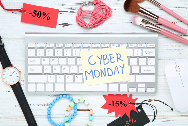 Inscription Cyber Monday with makeup brushes, bracelets and wristwatch keyboard on wooden background - Photo, Image