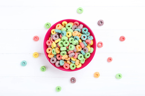 Colorful corn rings in bowl on white wooden table - Foto, immagini