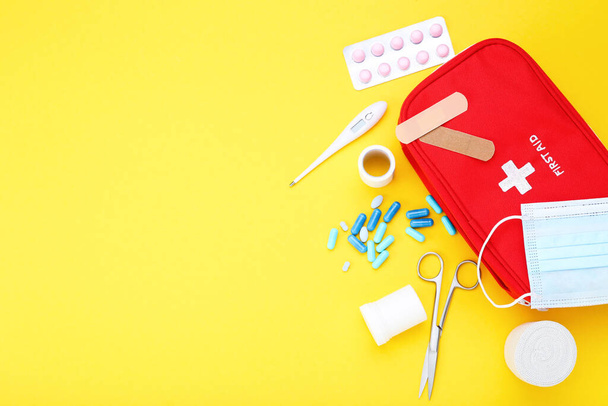 First aid kit with medical supplies on yellow background - Foto, immagini