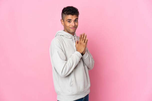 Young Brazilian man isolated on pink background scheming something - Photo, Image