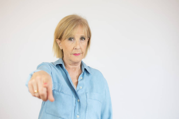 Yaşlı kadın parmağını kaldırmış ve kızgın bir ifadeyle işaret ediyor, hiç hareket göstermiyor. - Fotoğraf, Görsel