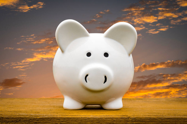 White piggy bank with twilight sky background. Saving or investment concept - Foto, Imagem