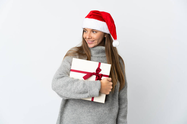 Lithianische Frau mit Weihnachtsmütze mit Geschenken auf weißem Hintergrund, die zur Seite schaut und lächelt - Foto, Bild