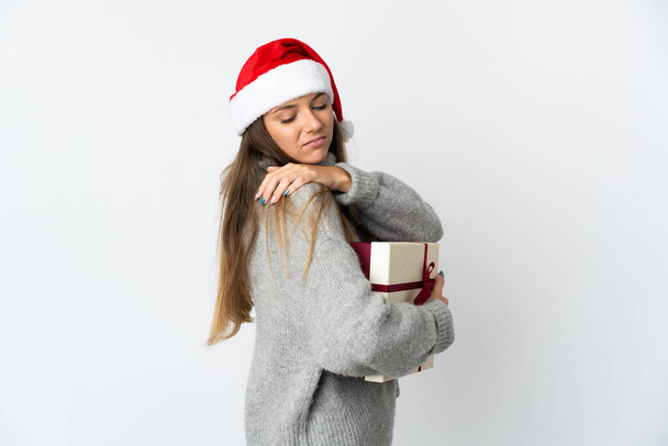 Lithianian woman with christmas hat holding presents isolated on white background suffering from pain in shoulder for having made an effort - Photo, image