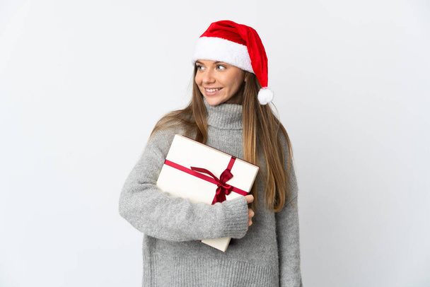 Lithianian woman with christmas hat holding presents isolated on white background looking side - Foto, imagen