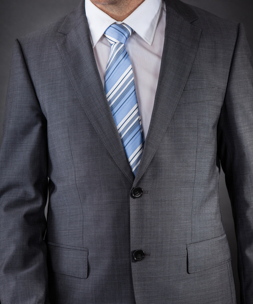 Чоловік одягнений в костюм з смугастою краваткою
 - Фото, зображення