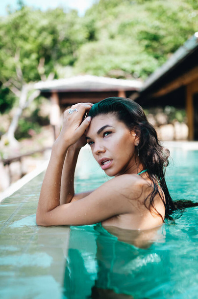 Beautiful long hair female model posing in the swimming pool - Fotografie, Obrázek