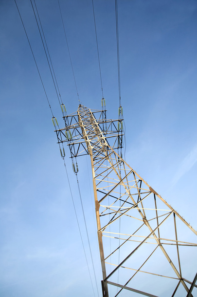 High-voltage power line metal prop  over clear cloudless blue sky - Foto, Imagem