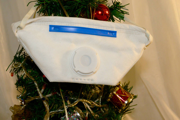 dekoratív karácsonyfa arc orvosi maszk fény háttér, coronavirus koncepció - Fotó, kép