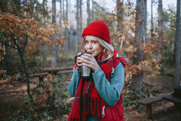 Woman backpacker drinking coffee in a forest - Foto, imagen