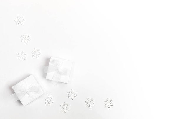 Arrangement of white Xmas Decorations: snowflakes and two DIY gift boxes on white. Christmas modern minimal composition. Top view, flat lay, copy space. - Fotoğraf, Görsel