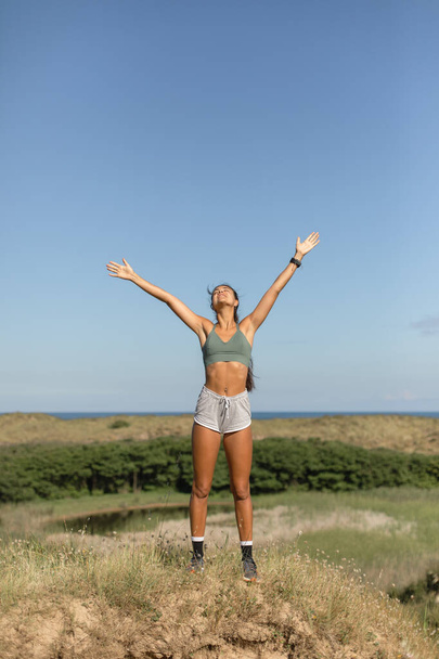 Sucesso no estilo de vida saudável. Desportivo bem-aventurado ajuste jovem mulher levantando braços para o céu. - Foto, Imagem