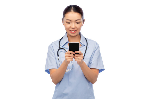 happy asian female doctor or nurse with smartphone - 写真・画像