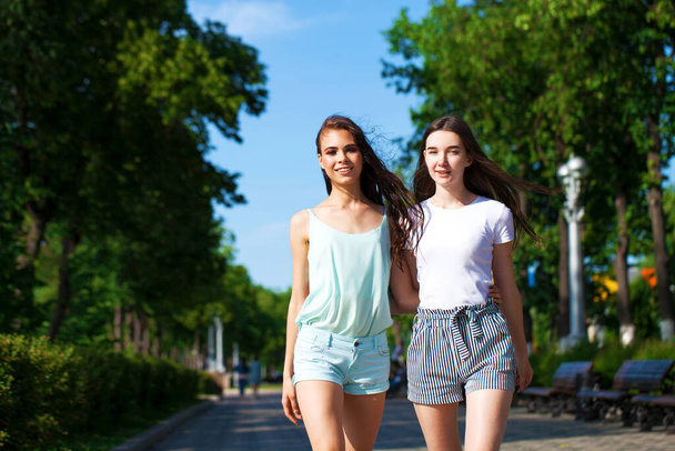 Happy Two girlfriends walking on summer street, outdoors - Фото, зображення