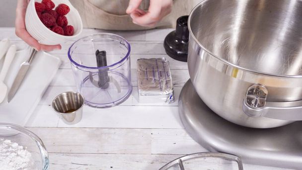 Preparación de crema de frambuesa crema de queso en mezclador de cocina para hornear cupcakes de chocolate con frambuesa. - Foto, imagen