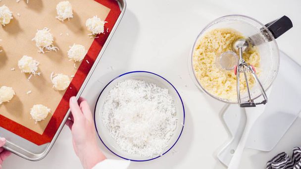 Flat lay. Scooping cookie dough into the baking sheet to bake coconut cookies. - Photo, Image