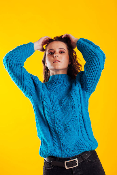 Portrait of a beautiful fashionable brunette woman in a blue winter sweater - Valokuva, kuva