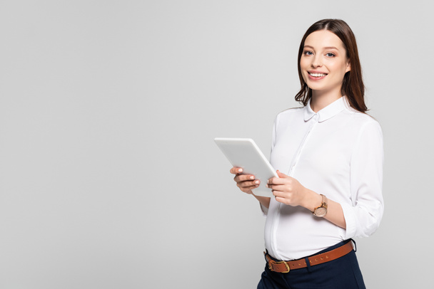 smiling young pregnant businesswoman with digital tablet isolated on grey - Foto, Bild
