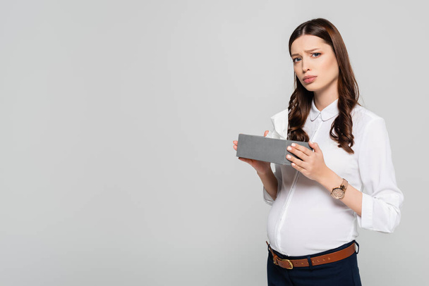 sad young pregnant businesswoman with napkins isolated on grey - Foto, afbeelding