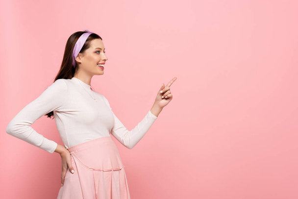happy young pretty pregnant woman pointing aside isolated on pink - Фото, зображення