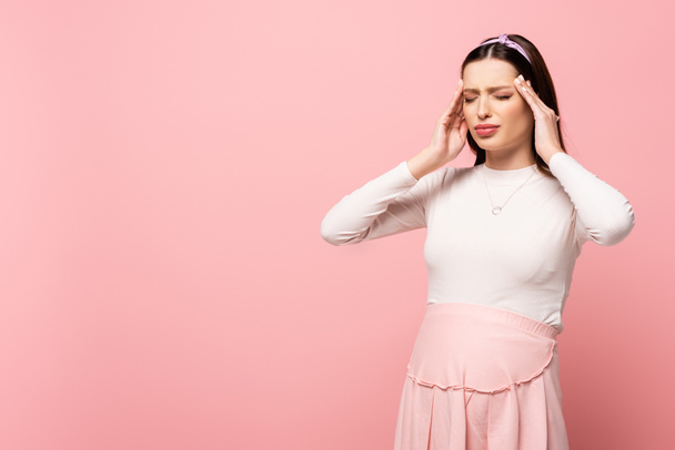 young pretty pregnant woman suffering from headache isolated on pink - Фото, изображение