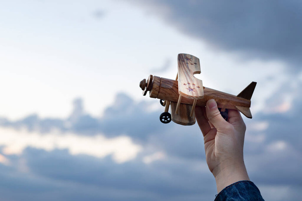 за руку держась за деревянный самолет - Фото, изображение
