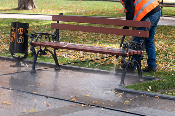 silne ciśnienie wody umyć ulicę, czyszczenie terenu parku jesienią - Zdjęcie, obraz
