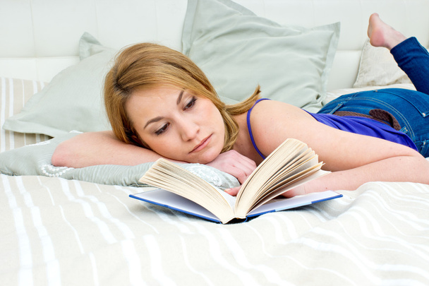 woman reading book in bed - Foto, afbeelding