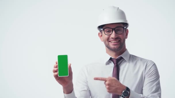 архитектор указывает пальцем на телефон с зеленым экраном, изолированным на белом - Кадры, видео