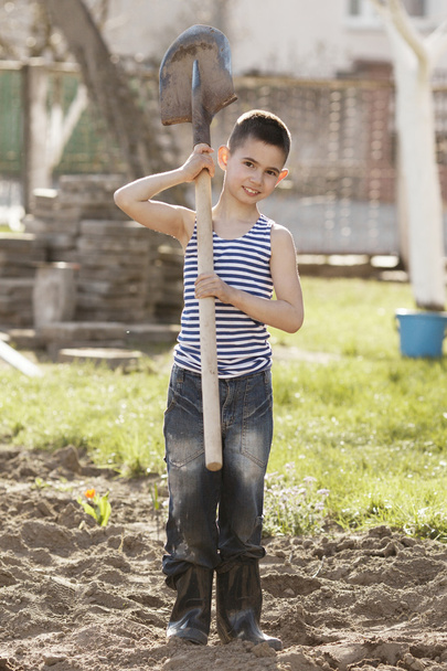 happy boy working with shovel in garden - Foto, afbeelding