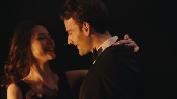Wesoła młoda para śmieje się podczas tańca na czarno  - Materiał filmowy, wideo