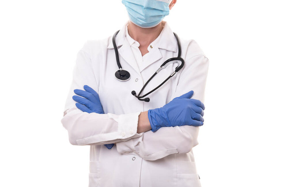 Young doctor in white uniform and stethoscope wearing mask on isolated background - Valokuva, kuva