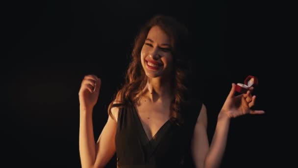 Jeune femme excitée avec un geste oui étui avec anneau isolé sur noir  - Séquence, vidéo