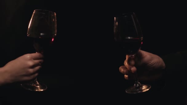 Vista parcial de pareja con copas de vino tostadas aisladas en negro  - Imágenes, Vídeo