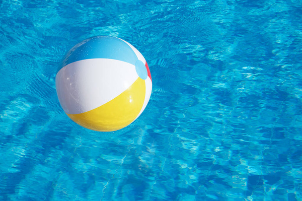 Bola inflable colorida flotando en la piscina - Foto, imagen