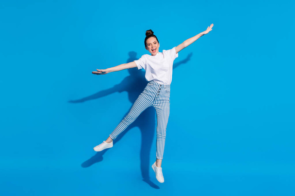 Full size photo of excited enthusiastic cheerful girl jump hold hand enjoy free time weekend wear good look clothes sneakers isolated over bright color background - Foto, Imagem