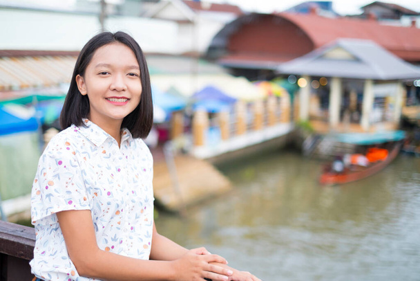 Азиатская девушка улыбается с видом на реку и старый город. - Фото, изображение