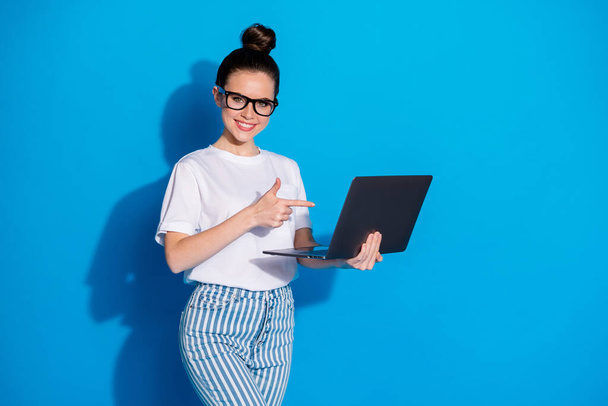 Portrait of nice attractive lovely content skilled cheery girl insurance manager consultant holding in hand demonstrating screen monitor laptop isolated bright vivid sine vibrant blue color background - Fotografie, Obrázek